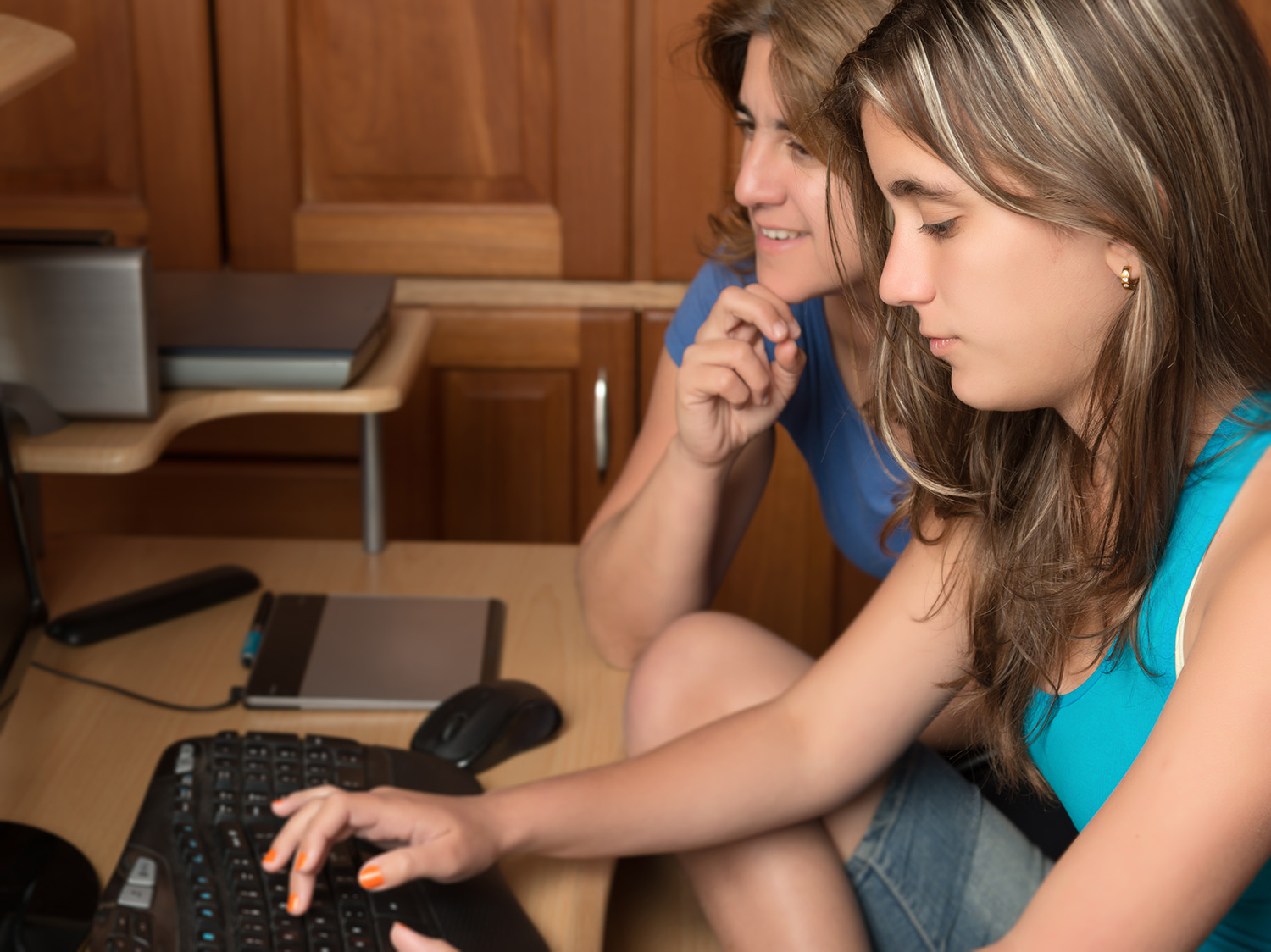 Teen girl on laptop with mom's support