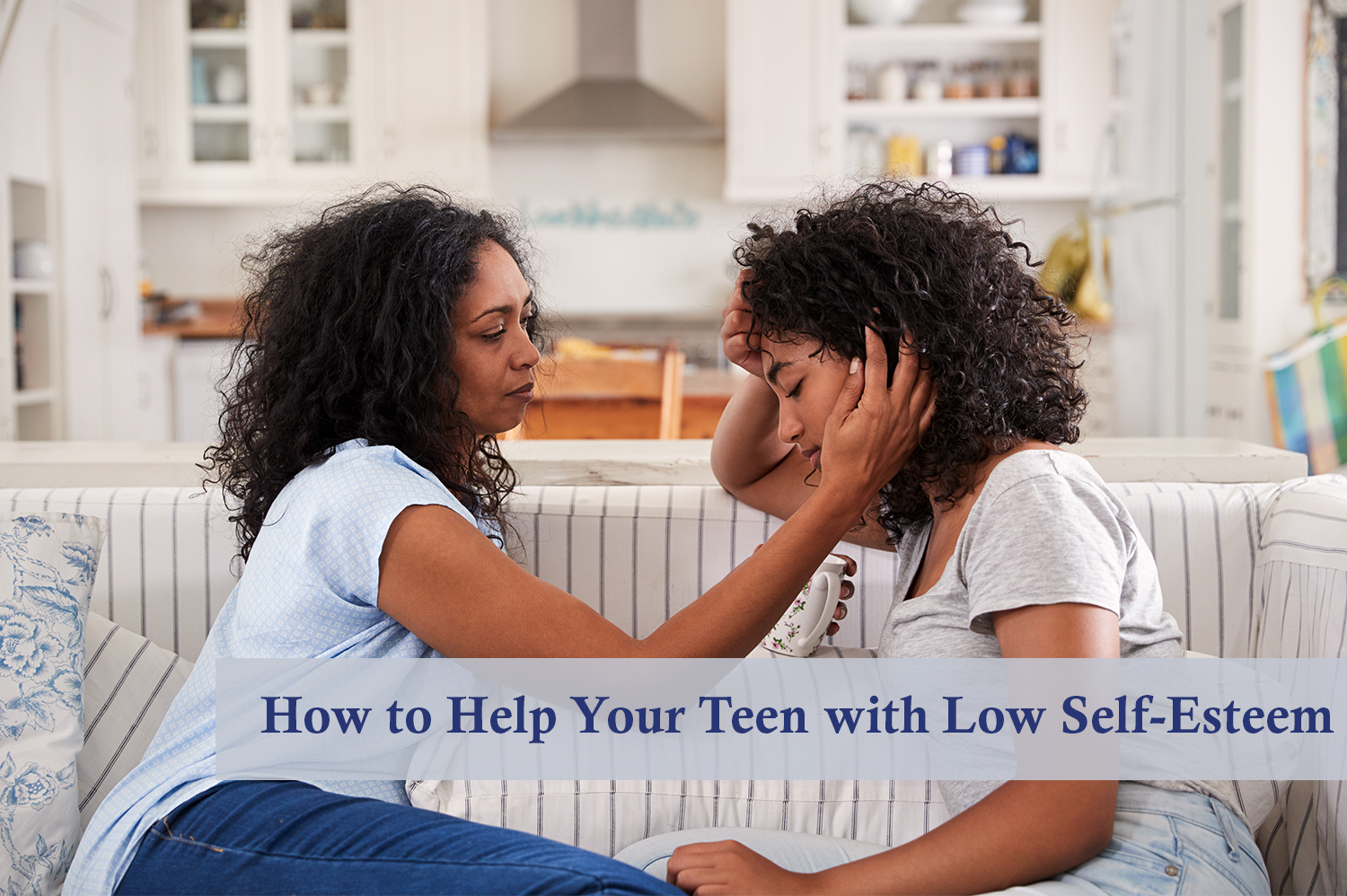 Teen with low self-esteem talking to her mom on a couch next to their kitchen.