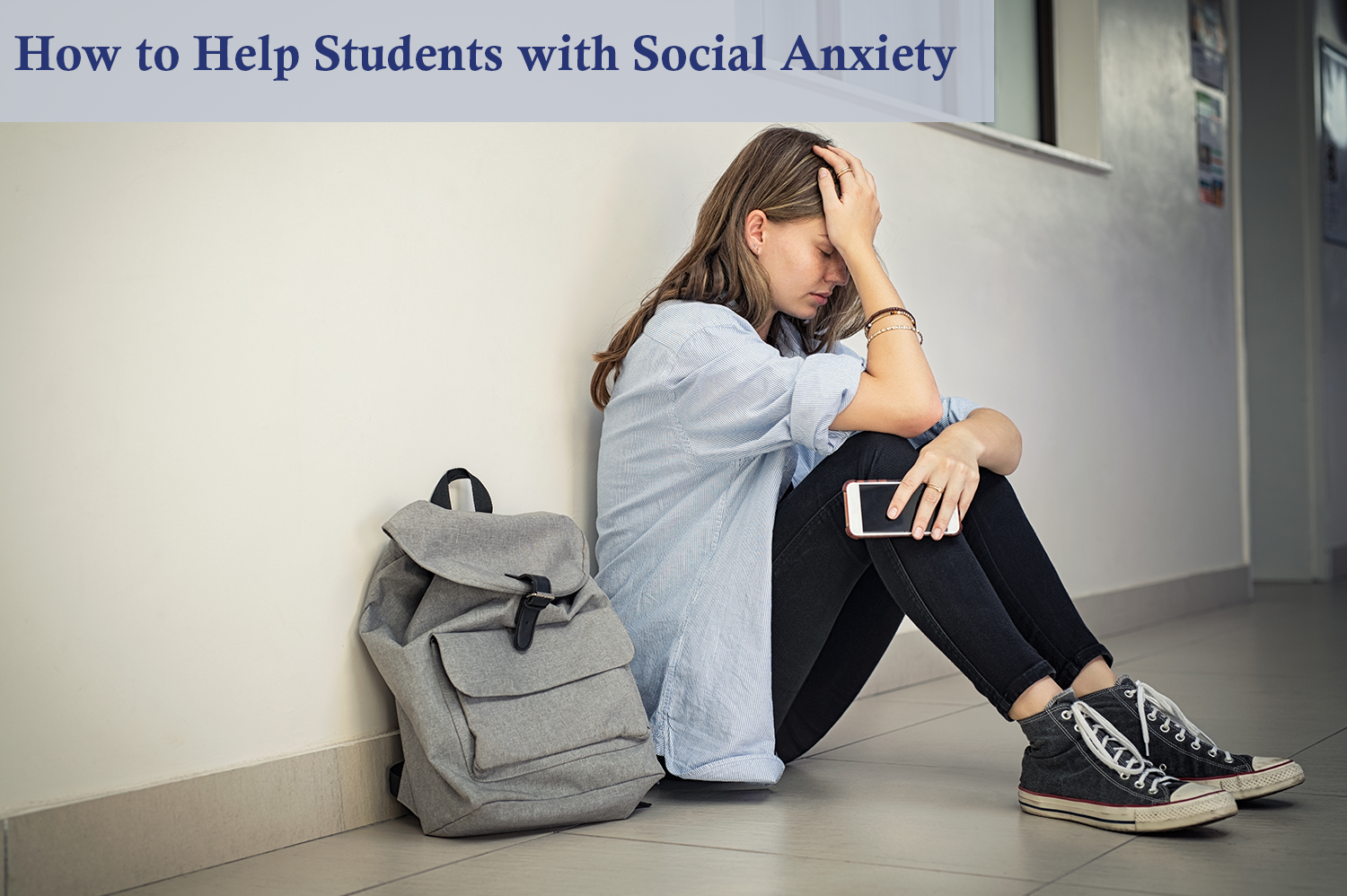Teenage girl sitting on school hallway next to a grey backpack with head help in hand, suffering from social anxiety.